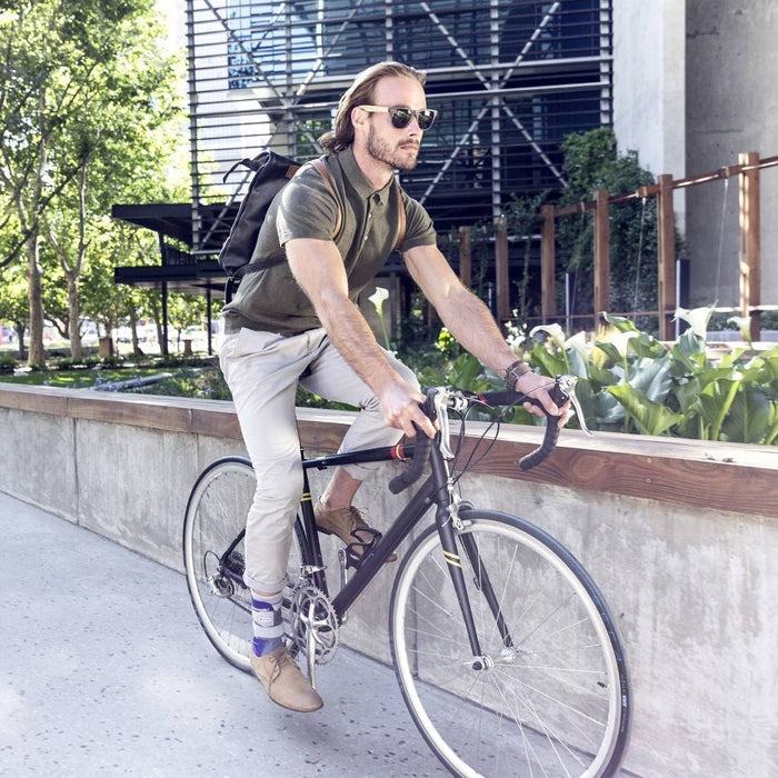 Man riding a bicycle wearing the MalleoLoc L3 Ankle Brace.
