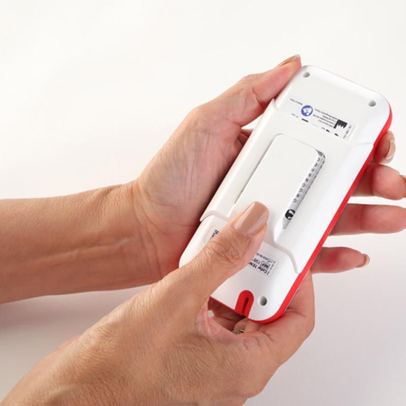 Hands holding a Cefar Muscle Stimulator displaying the back of the device.