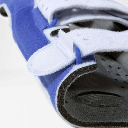 Close-up of a blue ManuLoc wrist brace showing adjustable Velcro straps and breathable material.